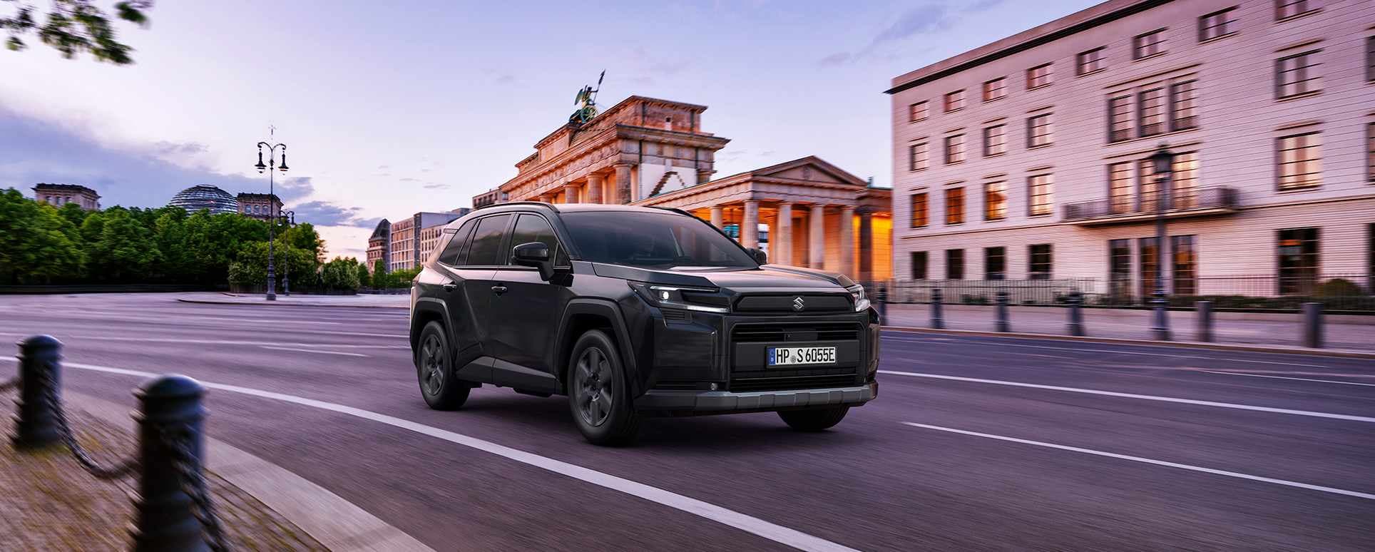 Ein dunkelgrauer Suzuki Across fährt auf einer Straße durch eine Stadt
