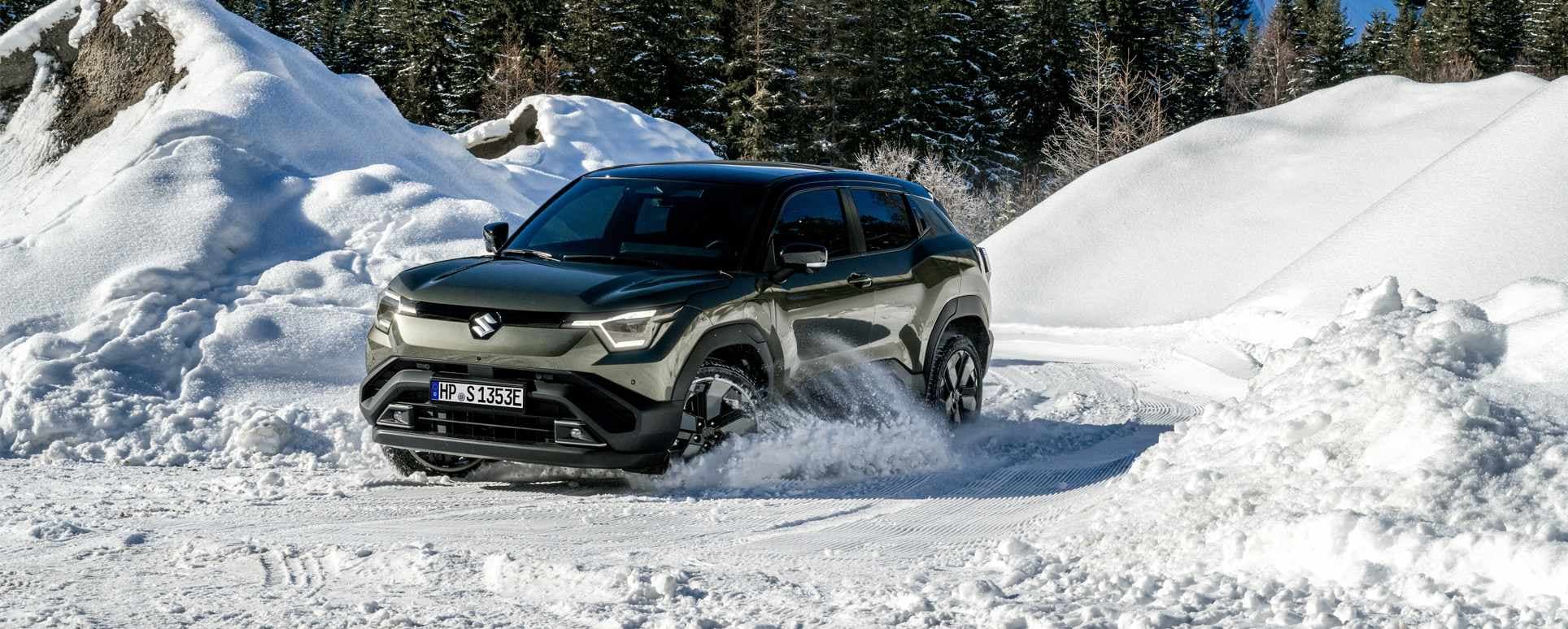 Abbildung zeigt dynamisch fahrenden e Vitara auf einer schneebedeckten Landstraße