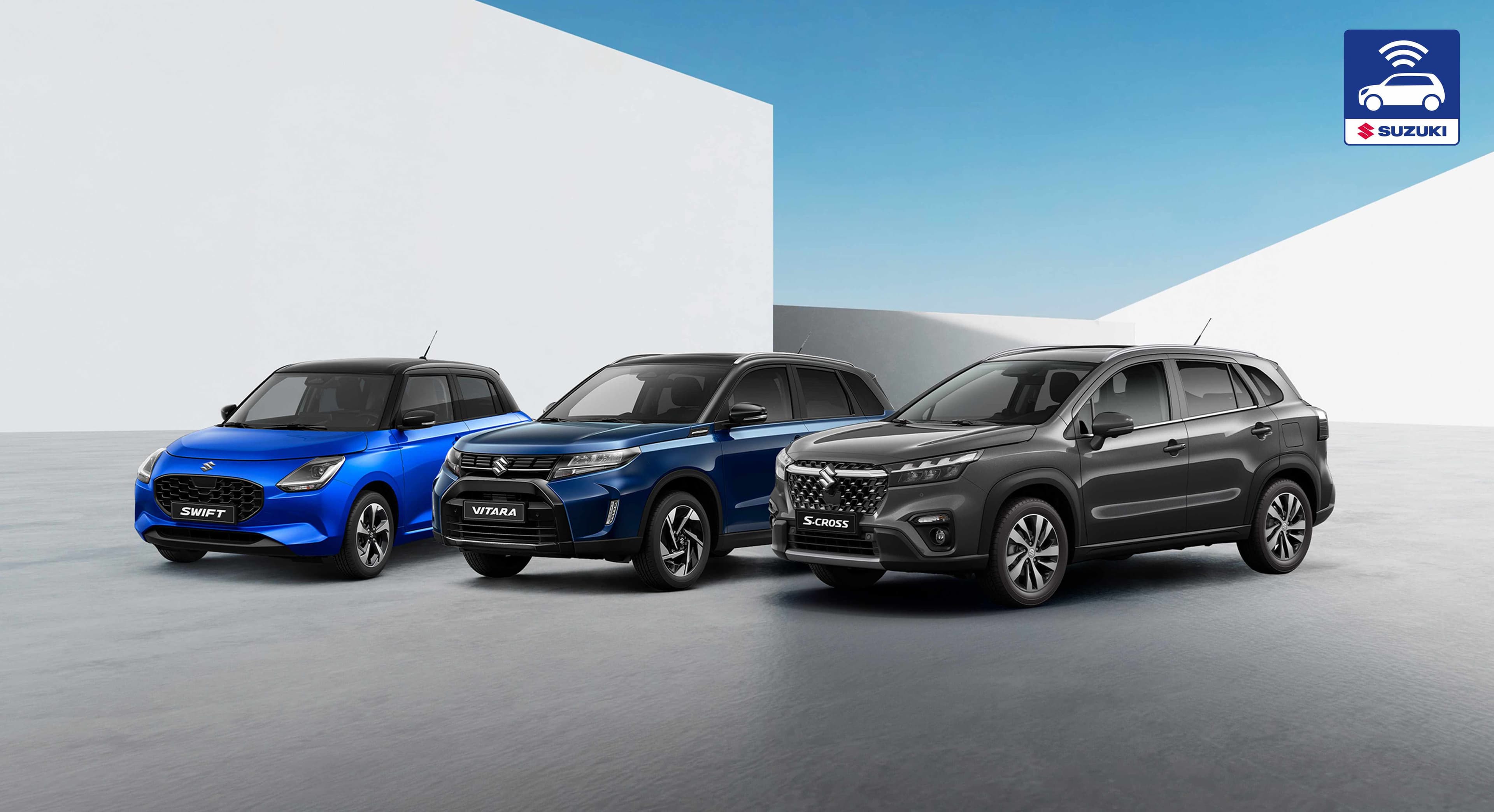 Von links nach rechts stehen ein blauer Suzuki Swift, ein dunkelblauer Suzuki Vitara und ein grauer Suzuki S-Cross auf einer freien Fläche.