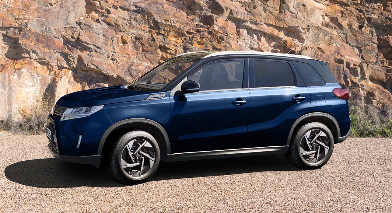 Seitenansicht eines dunkelblauen Suzuki Vitara vor einer Felswand