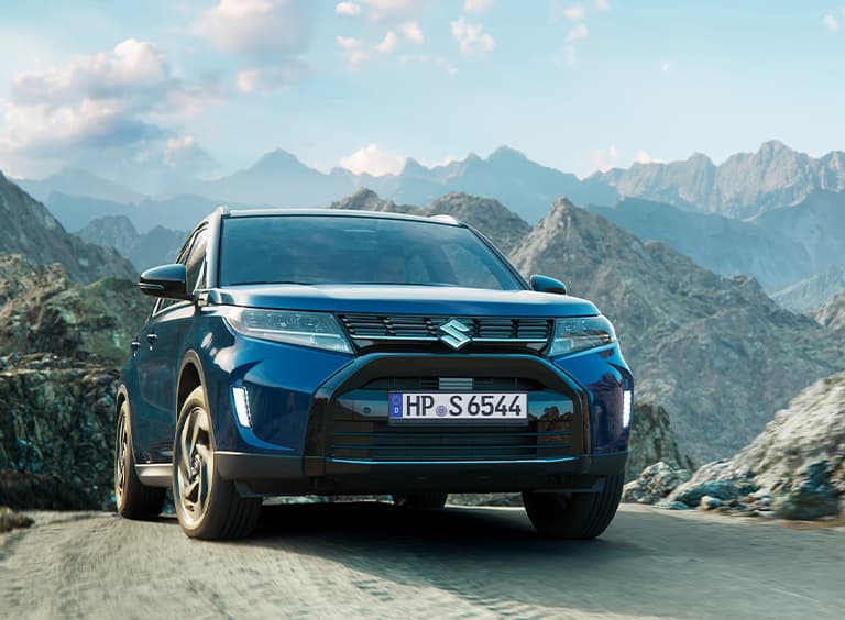 Vitara steht auf einem Hügel vor einer Bergkette