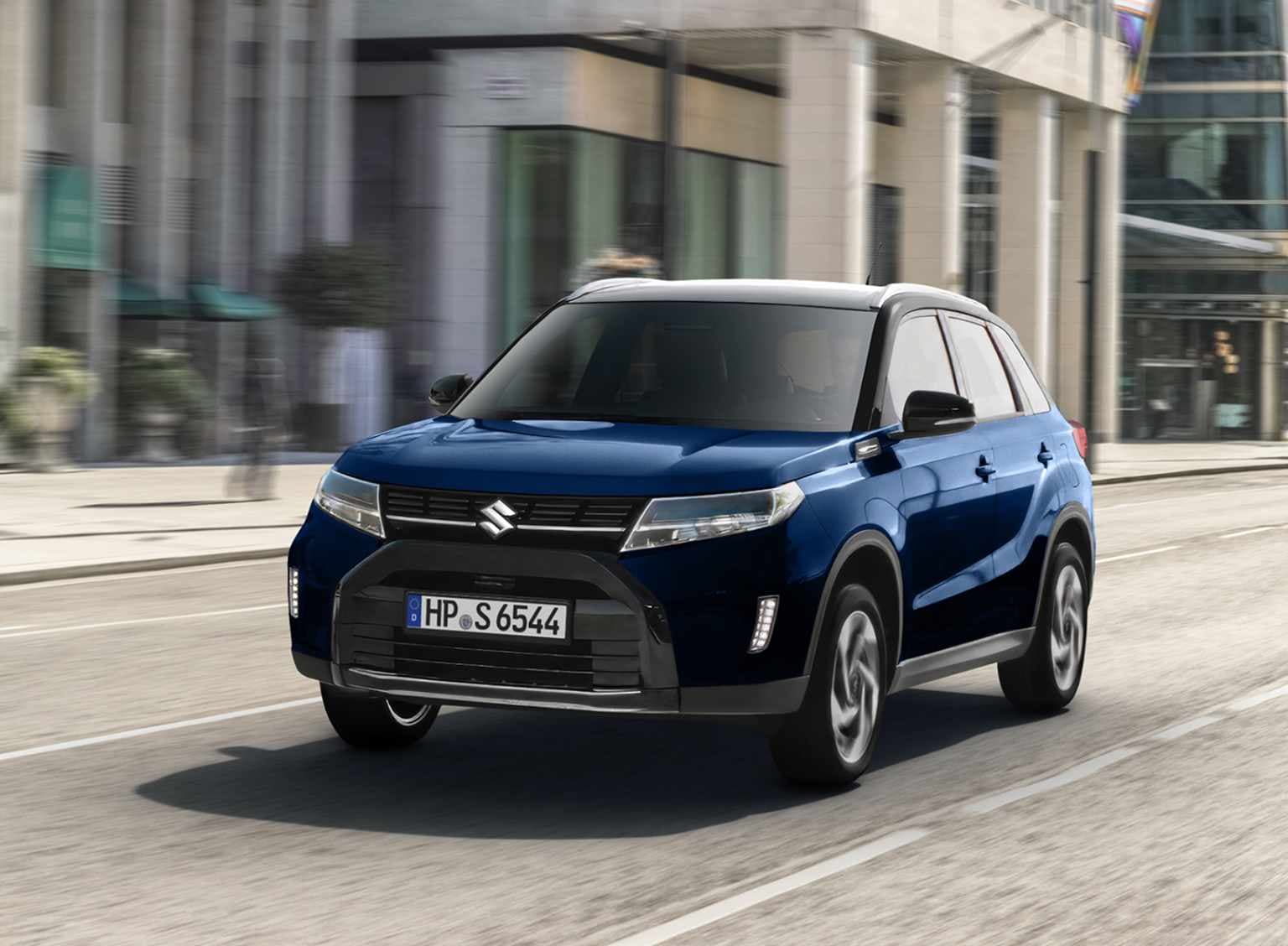 Dunkelblauer Suzuki Vitara Hybrid vor oranger Farbexplosion – Suzuki Deals, 5,3 l/100 km, CO₂ 120 g/km, Klasse D