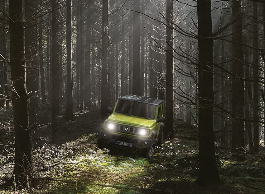 Ein Jimny fährt durch einen Wald