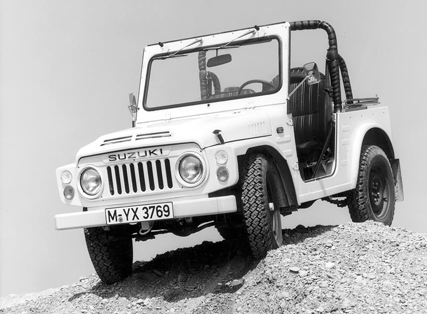 Abbildung zeigt ein schwarz-weiß Foto eines parkenden Jimnys auf einem Steinhügel