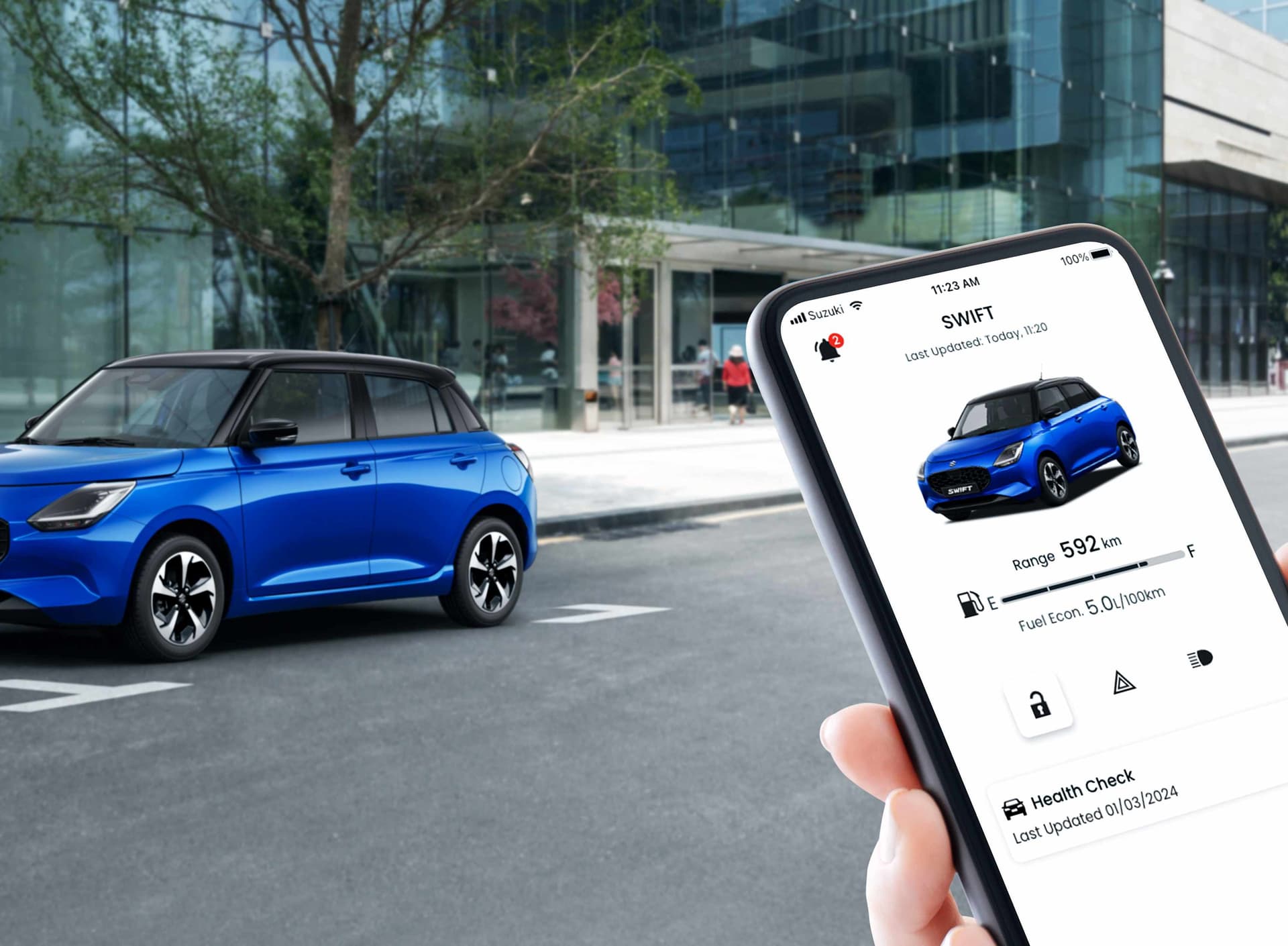 Smartphone zeigt blauen Suzuki Swift und im Hintergrund steht der gleiche Wagen auf der Straße
