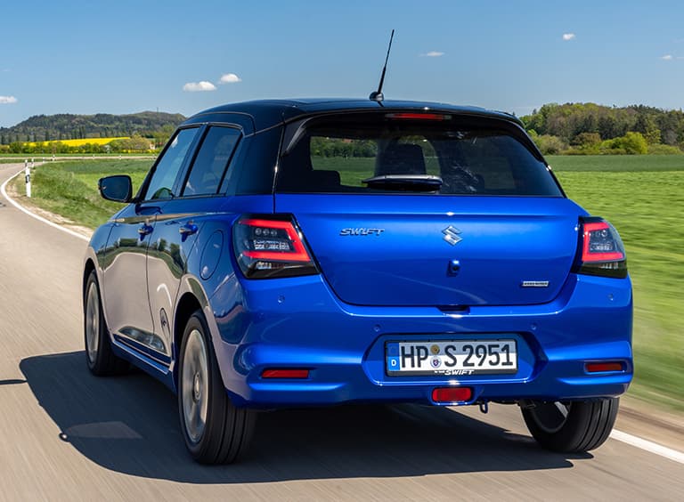 Abbildung zeigt Heckdesign eines blauen Swifts fahrend auf einer Straße