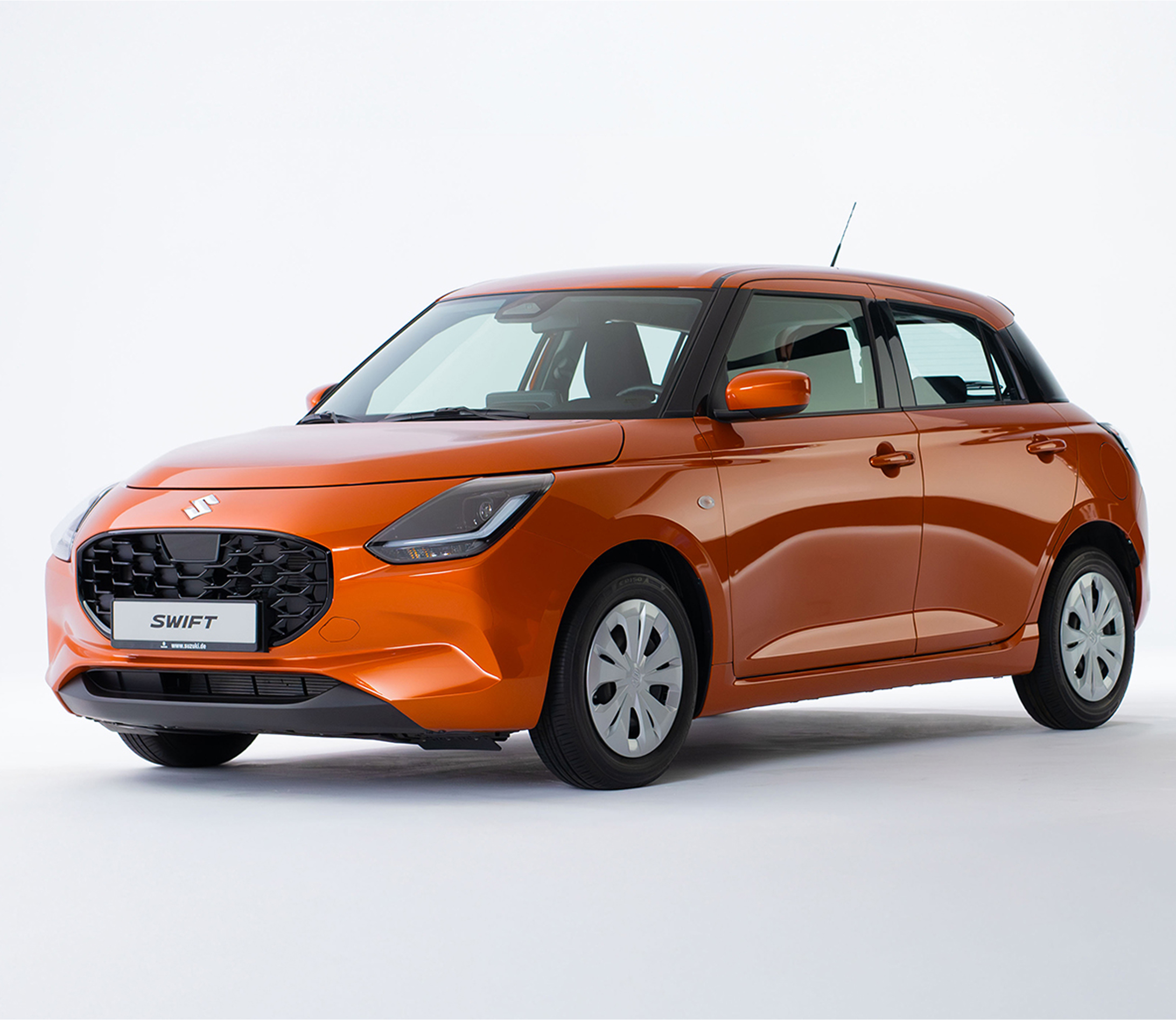 Der Suzuki Swift in orange von schräg vorne vor einem neutralen weißen Hintergrund.