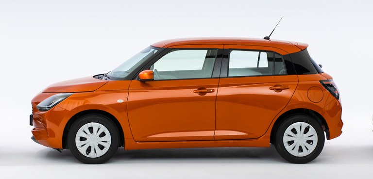 Der Suzuki Swift in orange steht seitlich vor neutralem weißen Hintergrund.