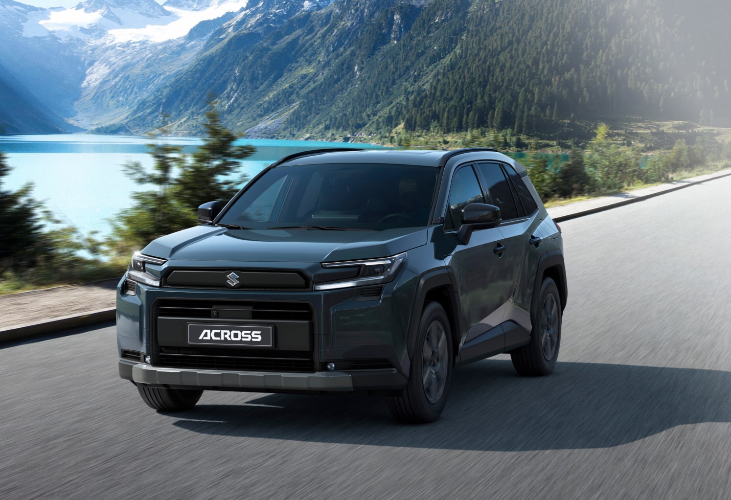 Der neue Suzuki Across von schräg vorne vor einem See mit Bergpanorama im Hintergrund.