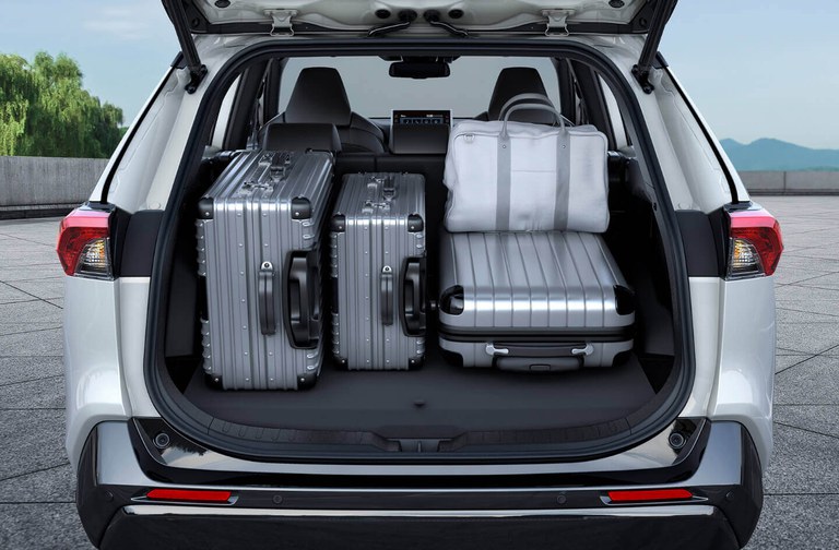 Suzuki Across Hybrid photographed from behind in White Pearl Crystal Shine Metallic with an open luggage compartment