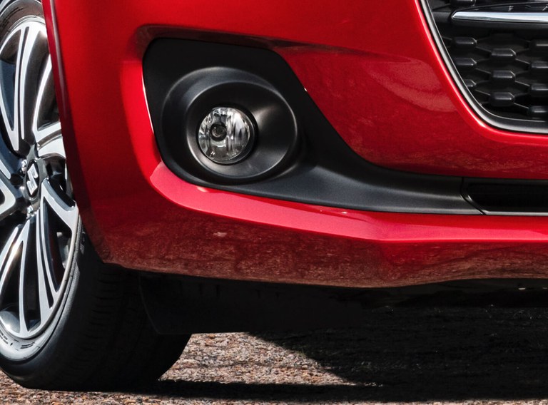Detailaufnahme des linken Nebelscheinwerfers eines Suzuki Swift Hybrid in Burning Red Pearl Metallic.