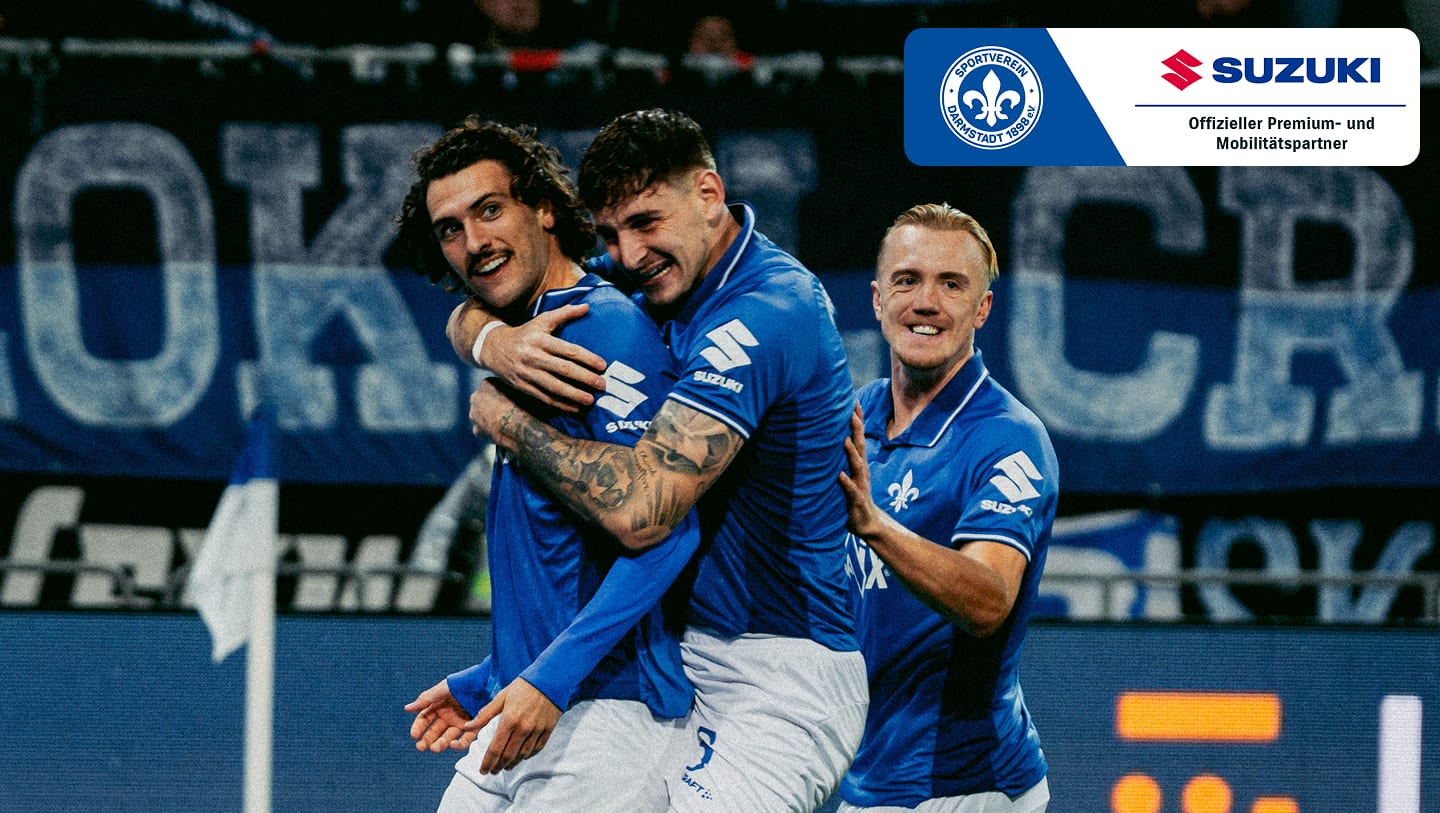 sportsponsoring_svdarmstadt98.jpg Drei Spieler des SV Darmstadt 98 in blauen Trikots jubeln gemeinsam auf dem Fußballplatz, Sponsor Suzuki im Bild.